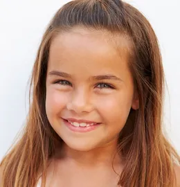 Child smiling with early orthodontic treatment